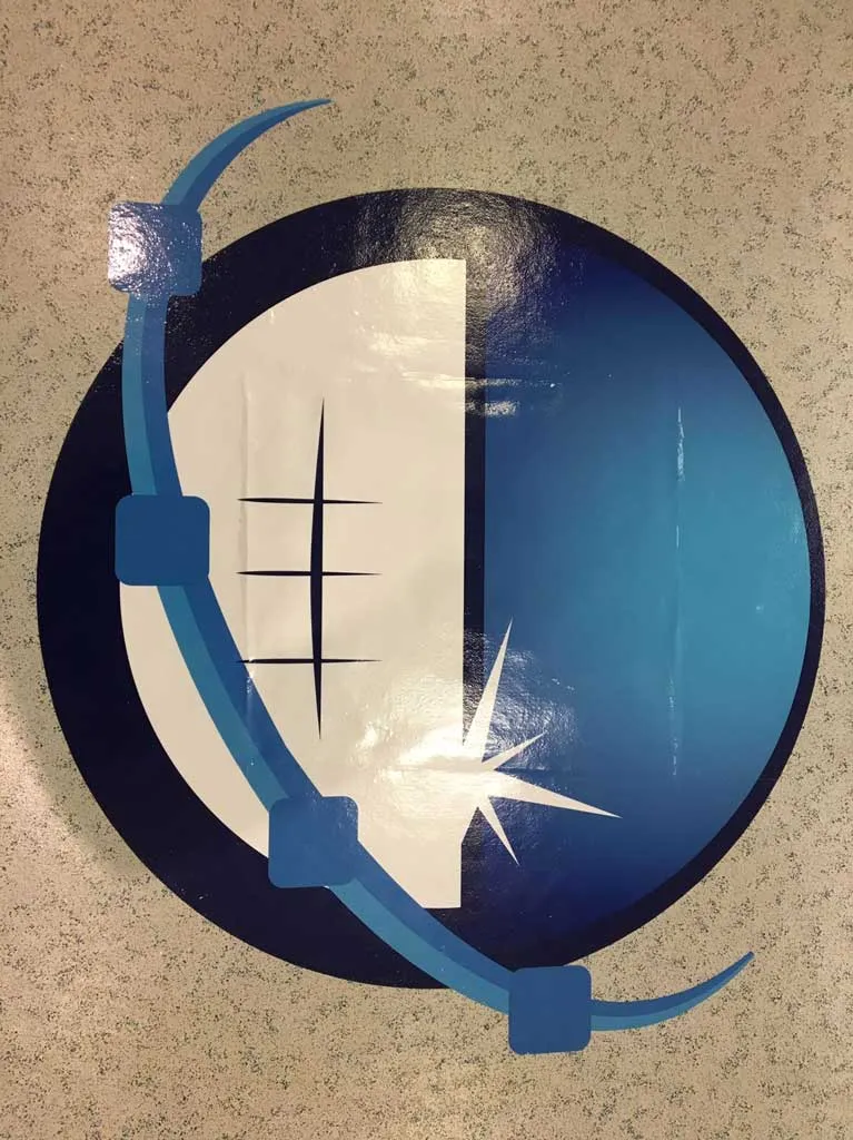 Circular navy and white printed floor graphic being applied to a tiled floor