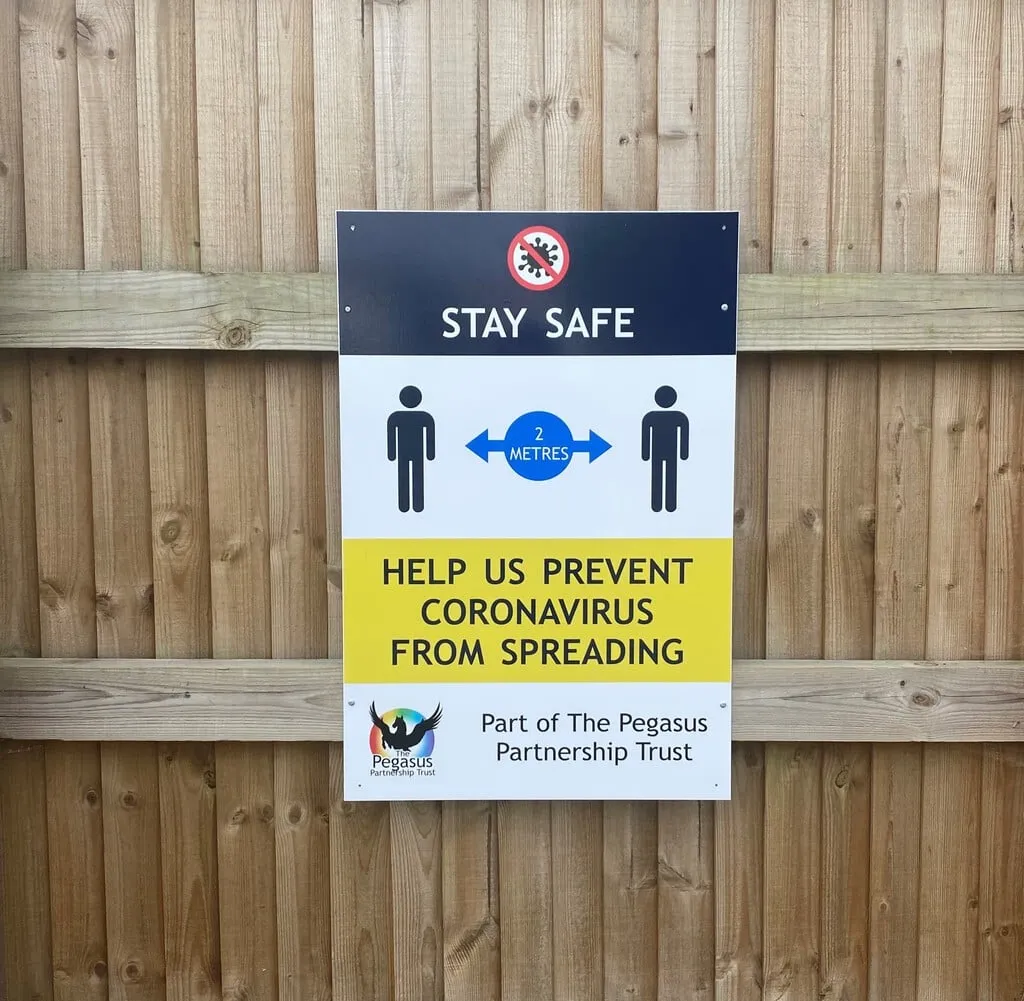 Stay Safe sign on a school fence asking people to keep 2 metres apart to help prevent coronavirus from spreading