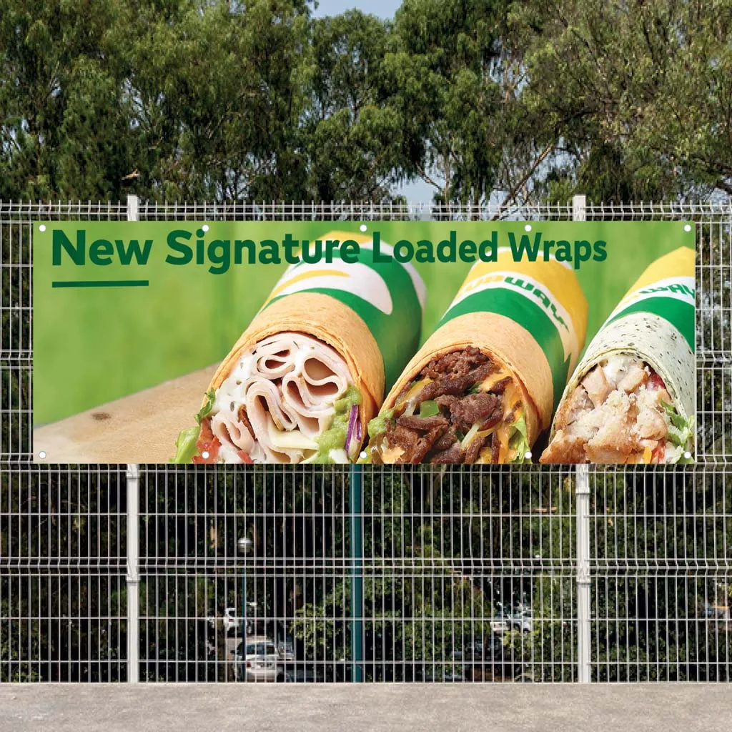 Printed vinyl banner advertising loaded wraps, fixed to a wire fence