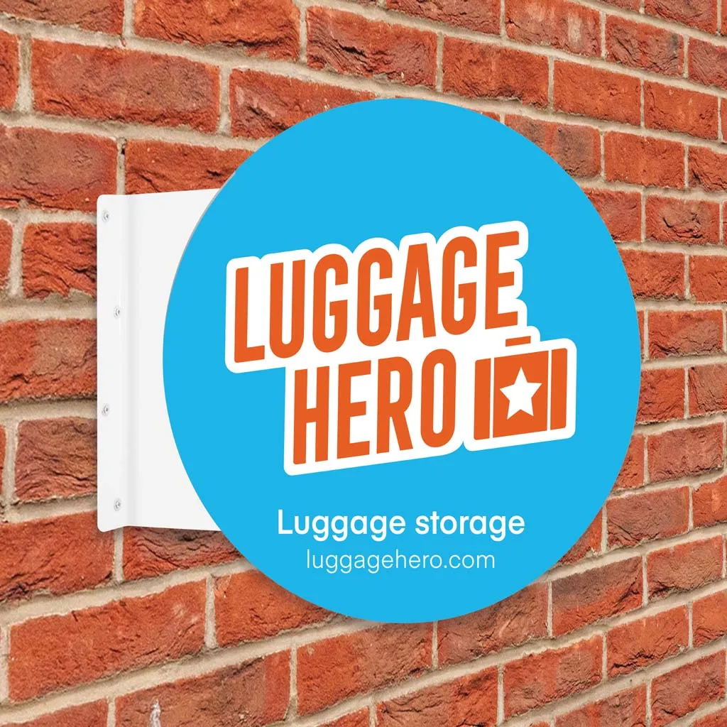 Round Luggage Hero projection sign fixed to a brick wall