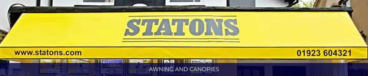 Yellow shop awning printed with a business name, website address and telephone number