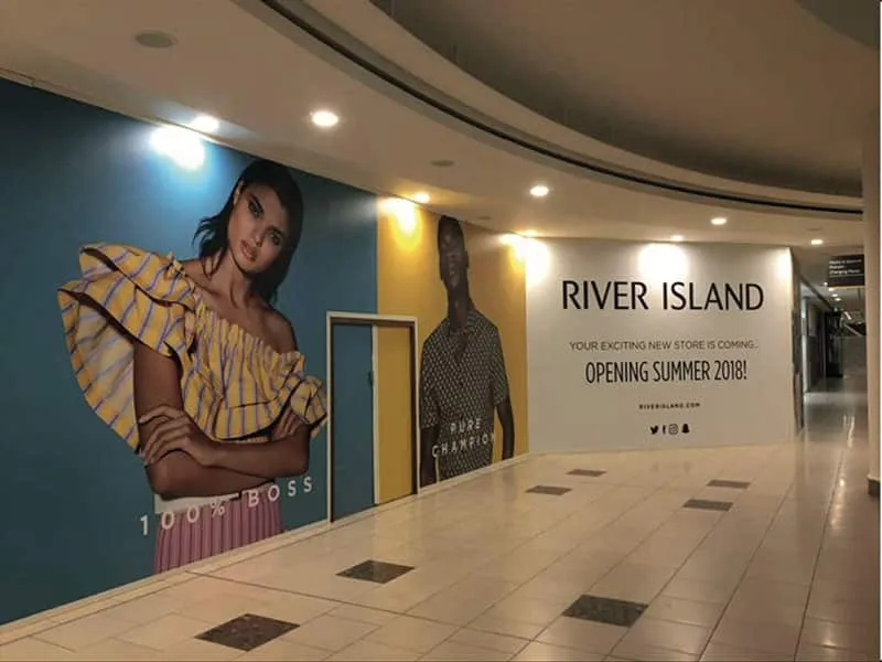 Large printed River Island wall graphics lining a shopping centre corridor