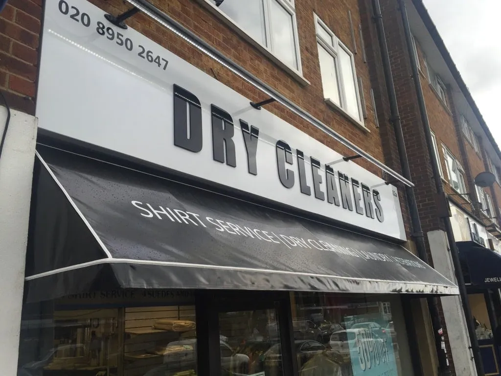 Raised Dry Cleaners lettering across a black and white shop awning