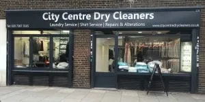 The City Centre Dry Cleaners shopfront, its black fascia sign board lettered in white above the window