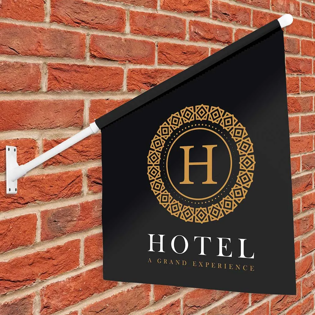 Black projection flag carrying a gold hotel crest, mounted on a brick wall