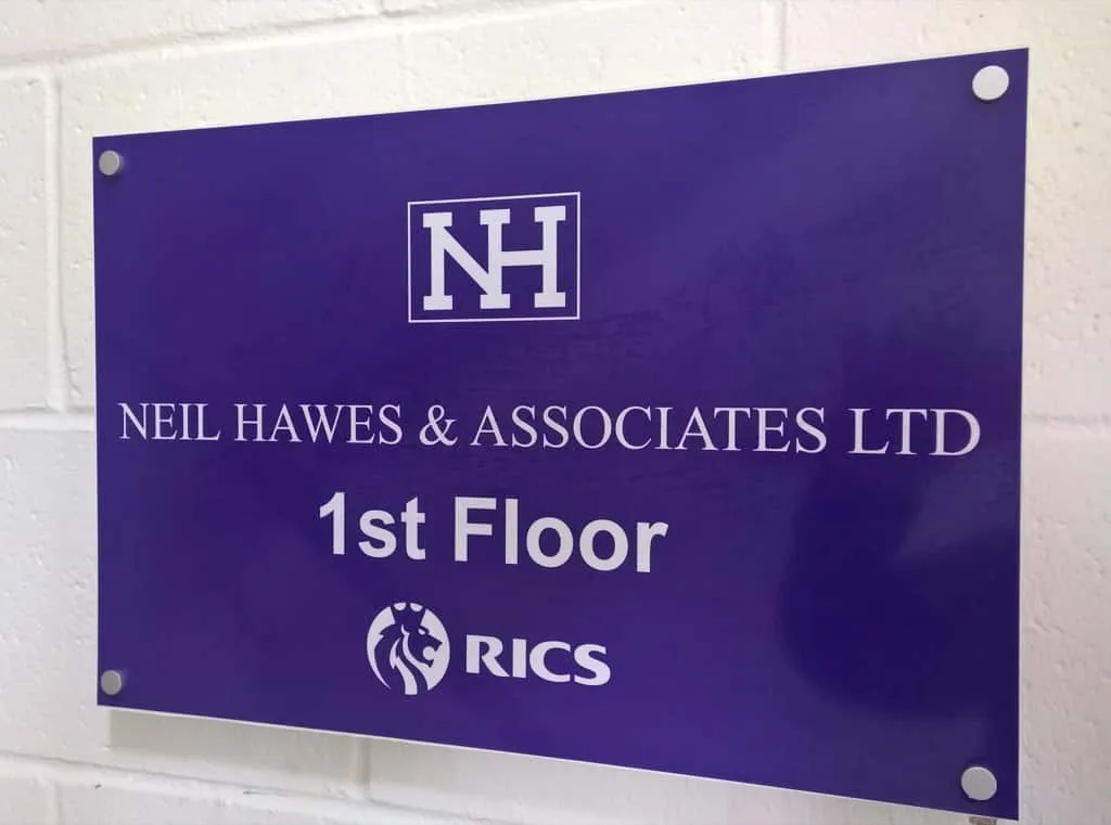 A purple acrylic plaque for Neil Hawes and Associates Ltd on the first floor, with an RICS logo